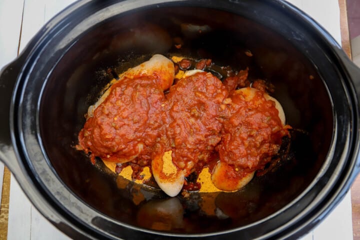 adding chicken salsa and other ingredients to slow cooker