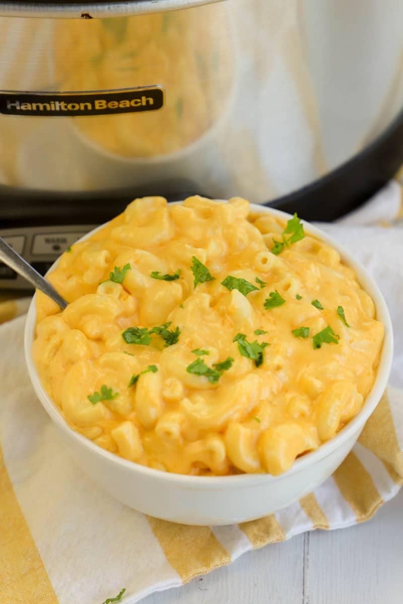 Slow Cooker Mac and Cheese in white bowl with slow cooker in the background