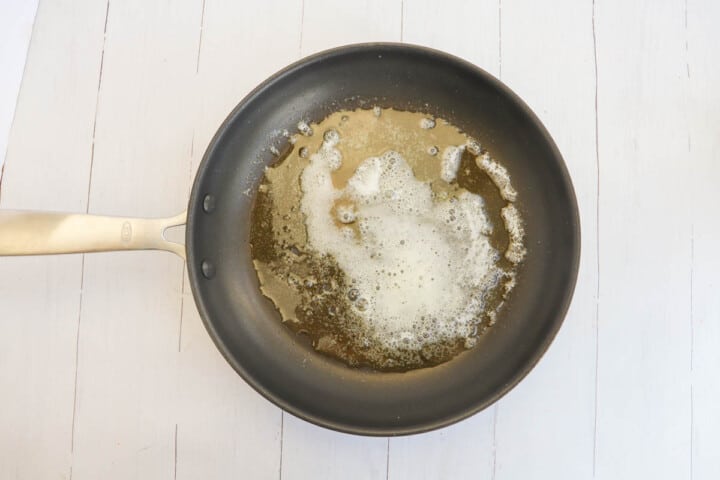 melting butter in pan to heat almonds