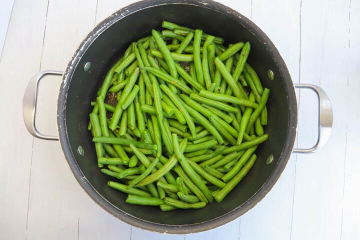 boiling the green beans in salt water in a pot