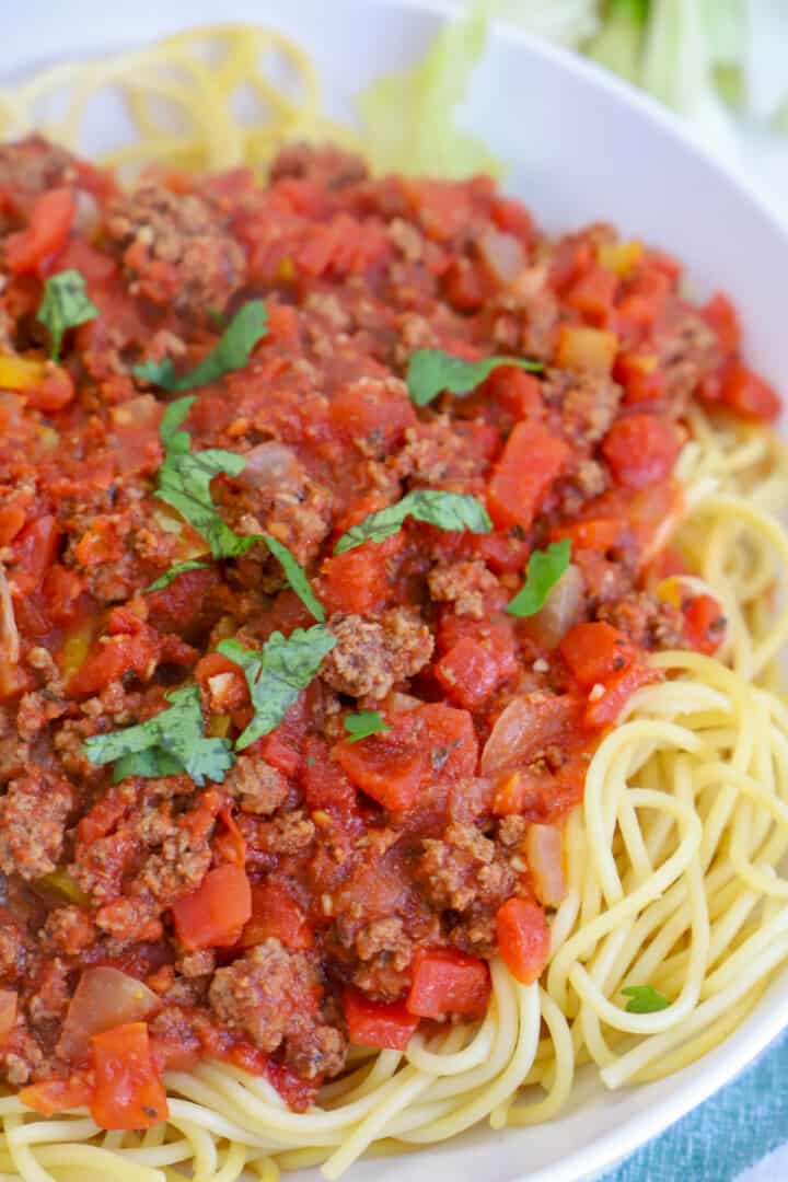 closeup of spaghetti sauce on top of noodles