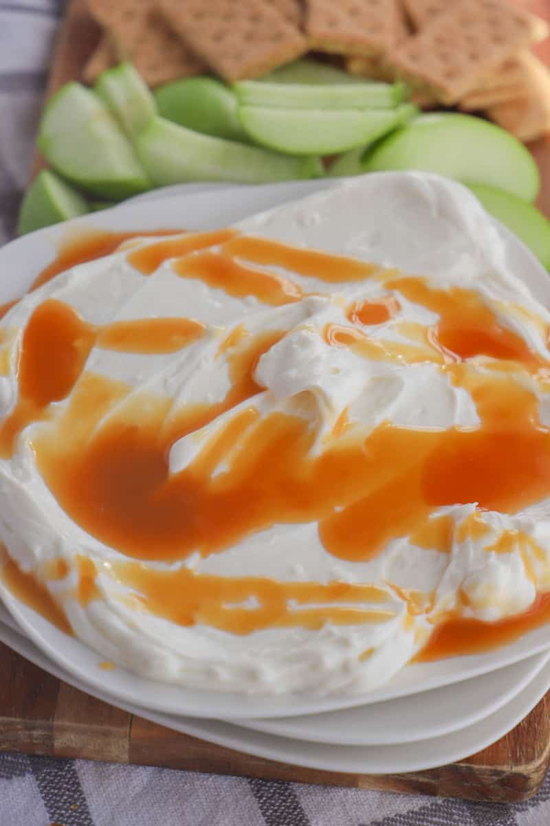 Caramel Cheesecake Dip on white plate with apple slices and graham crackers