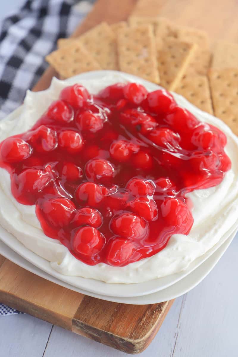 Cherry Cheesecake Dip on white plate with graham crackers