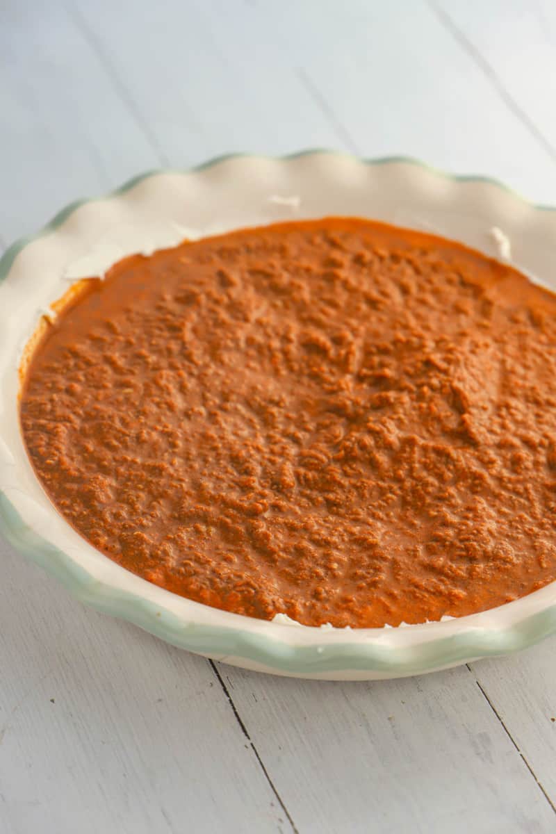 pouring the chili into the baking dish