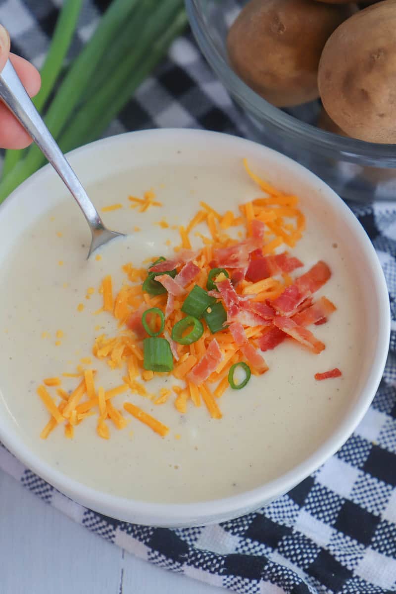 close up of slow cooker potato soup in white bowl