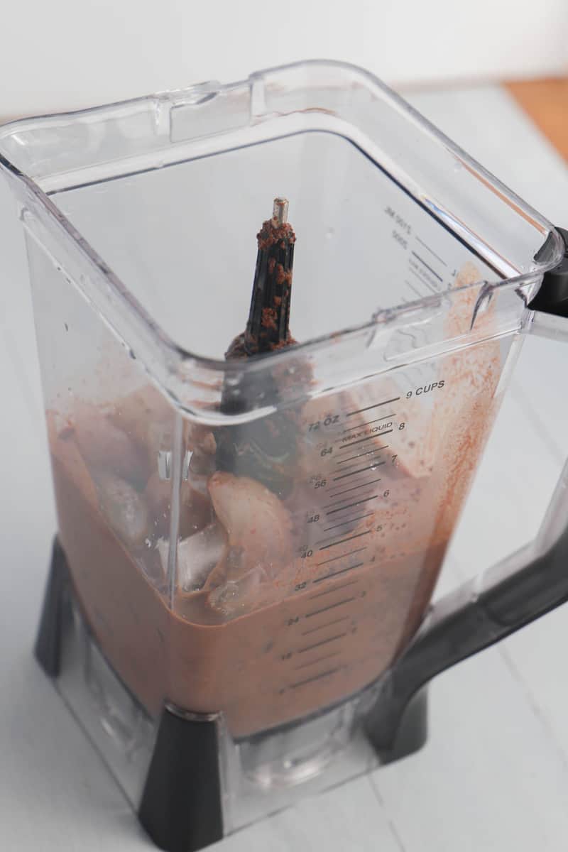 adding ice to the frozen hot chocolate mix in the blender