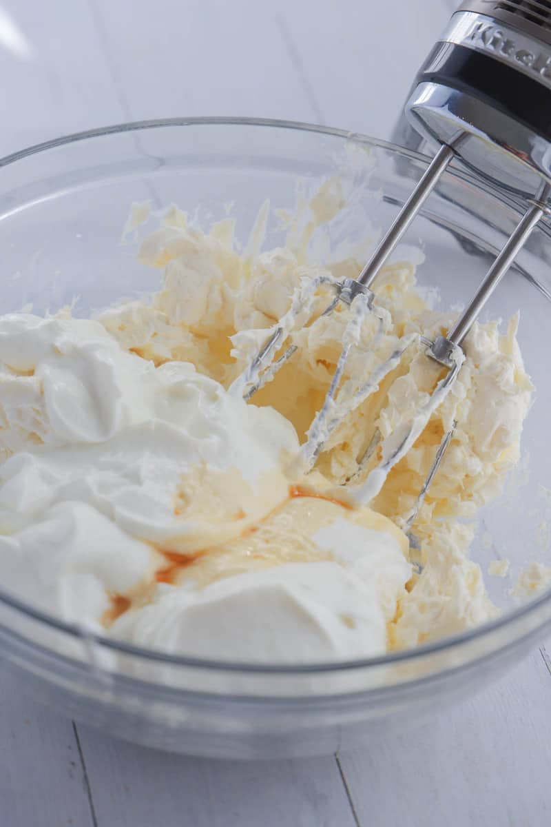 mixing together the Greek yogurt and cream cheese in glass bowl