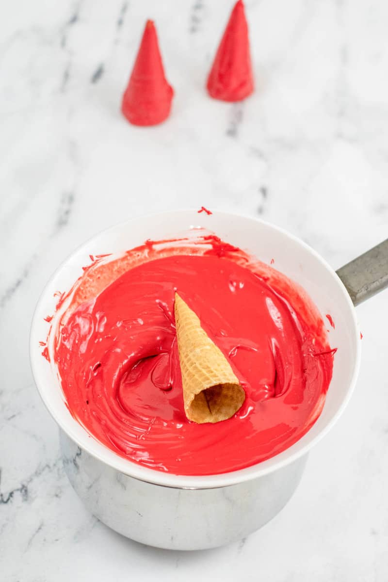 rolling the cones in the red melted candy icing