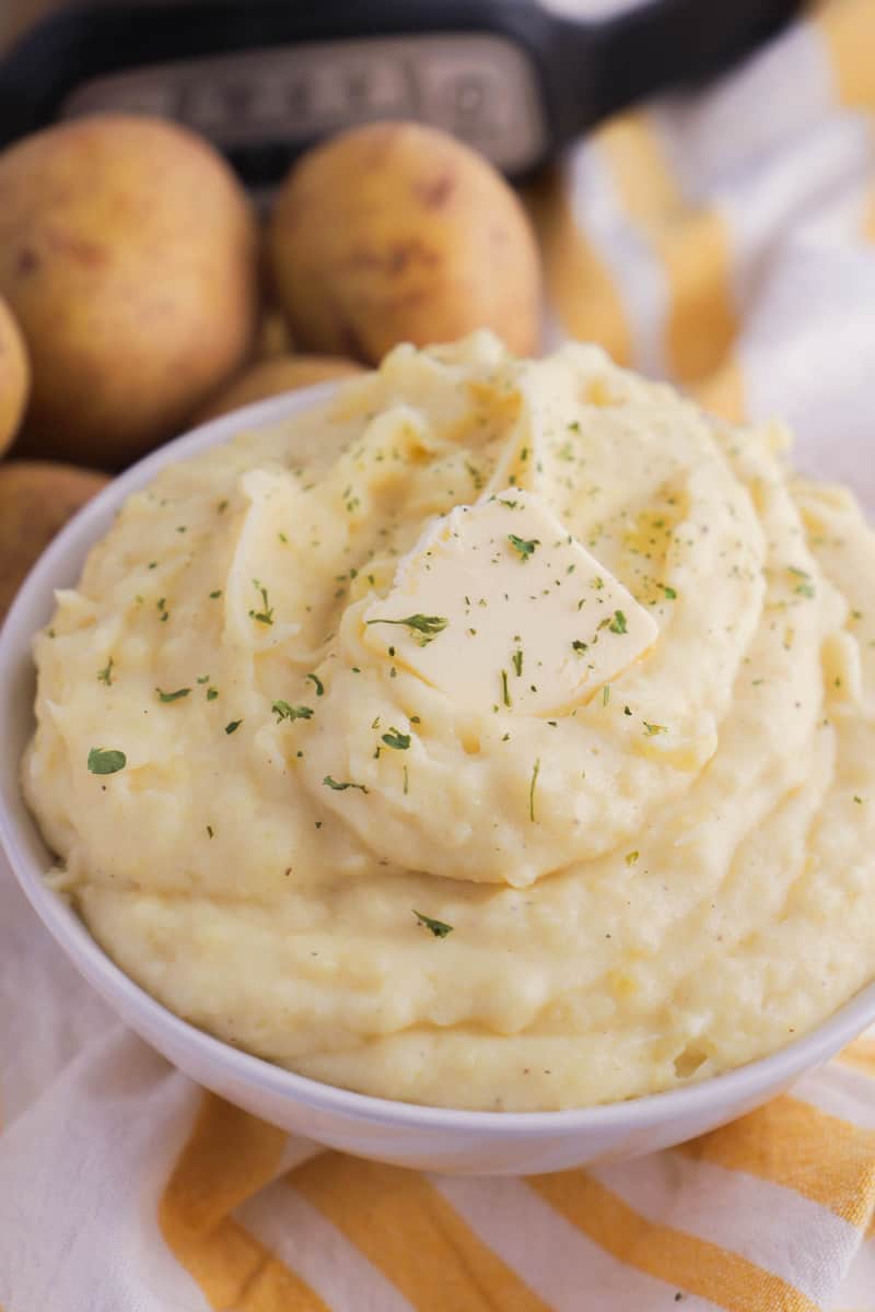 Slow Cooker Mashed Potatoes topped with parsley and butter