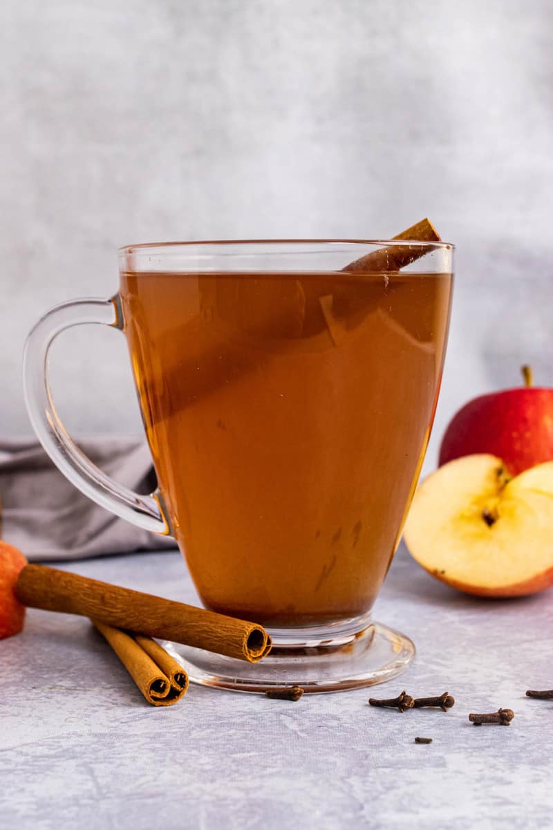 Slow Cooker Apple Cider in glass mug with cinnamon stick