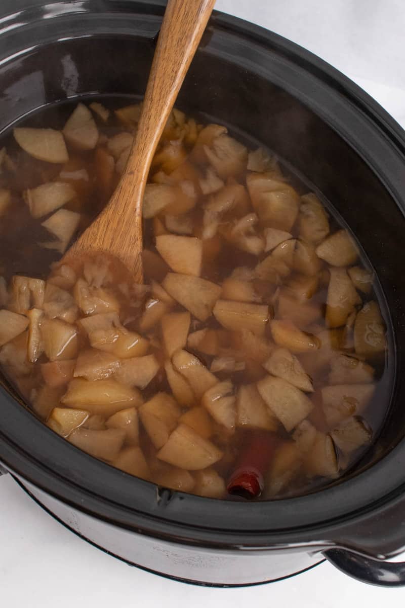 stirring cider in slow cooker