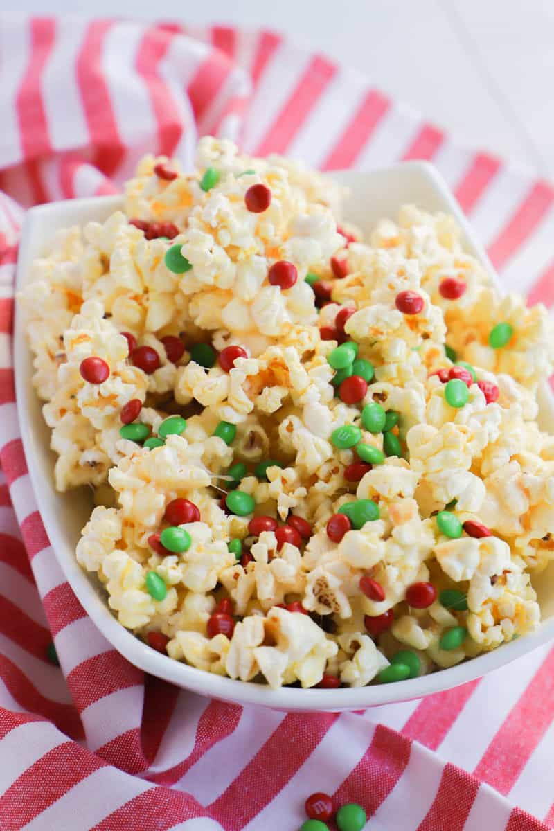 Christmas Popcorn in white serving bowl on red and white striped towel