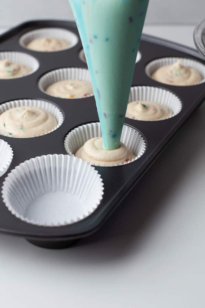 piping batter into cupcake liners
