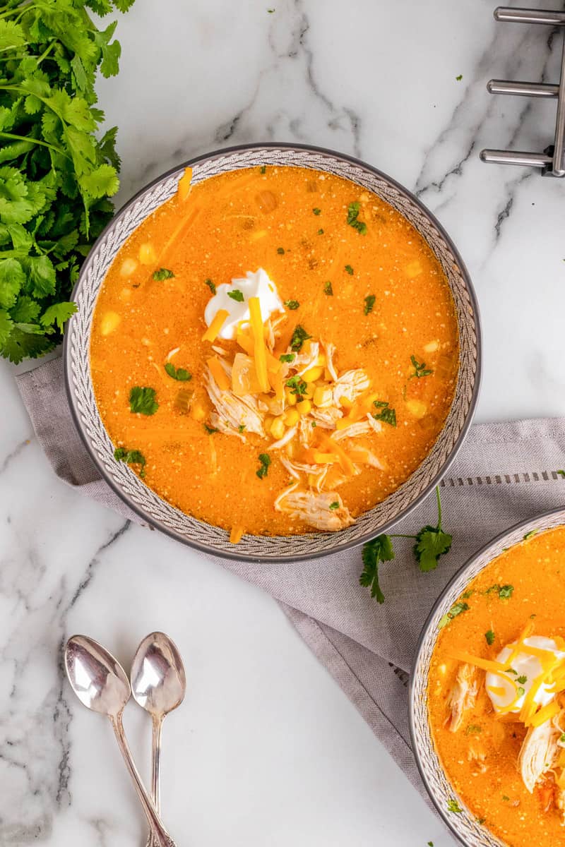 buffalo chicken soup in bowl topped with sour cream and cheese