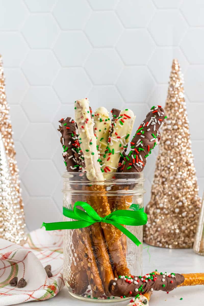 chocolate and white chocolate covered pretzel rods in mason jar with decorations