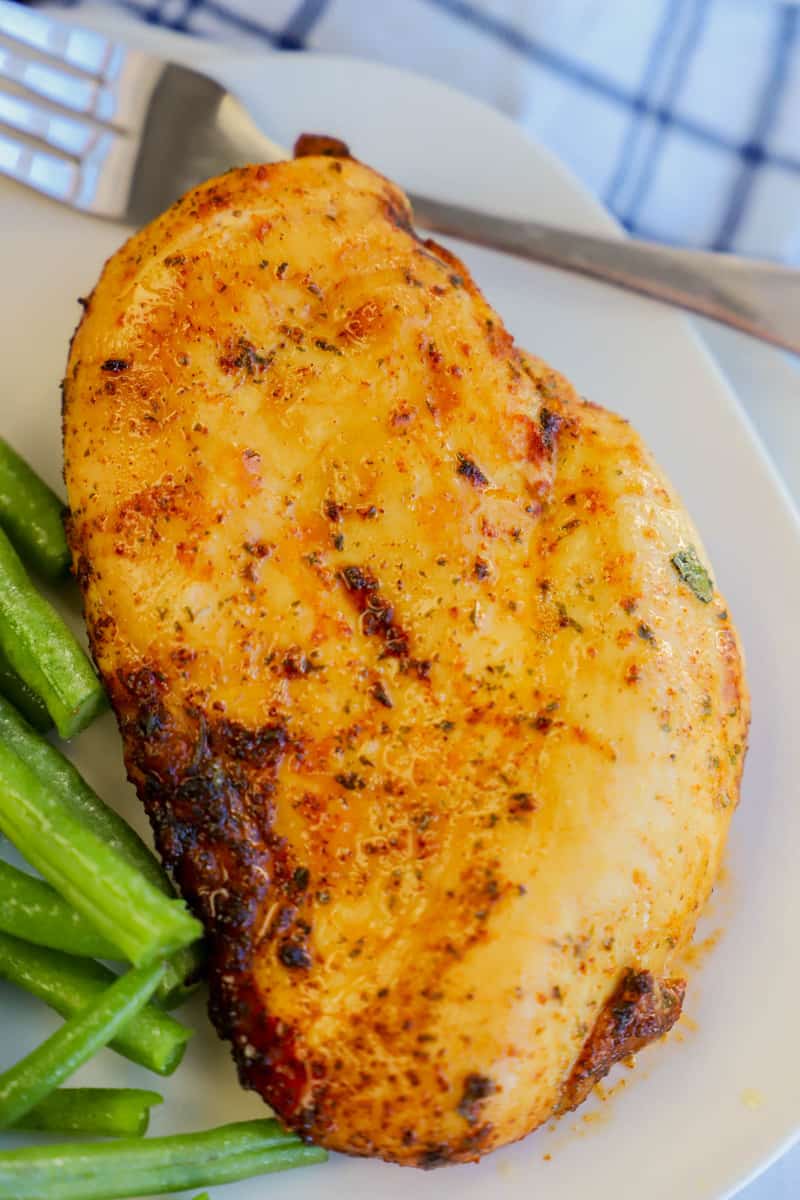 cooked chicken breast on white plate with green beans