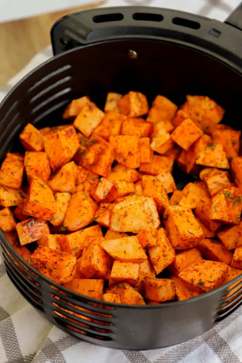placing sweet potatoes in the air fryer