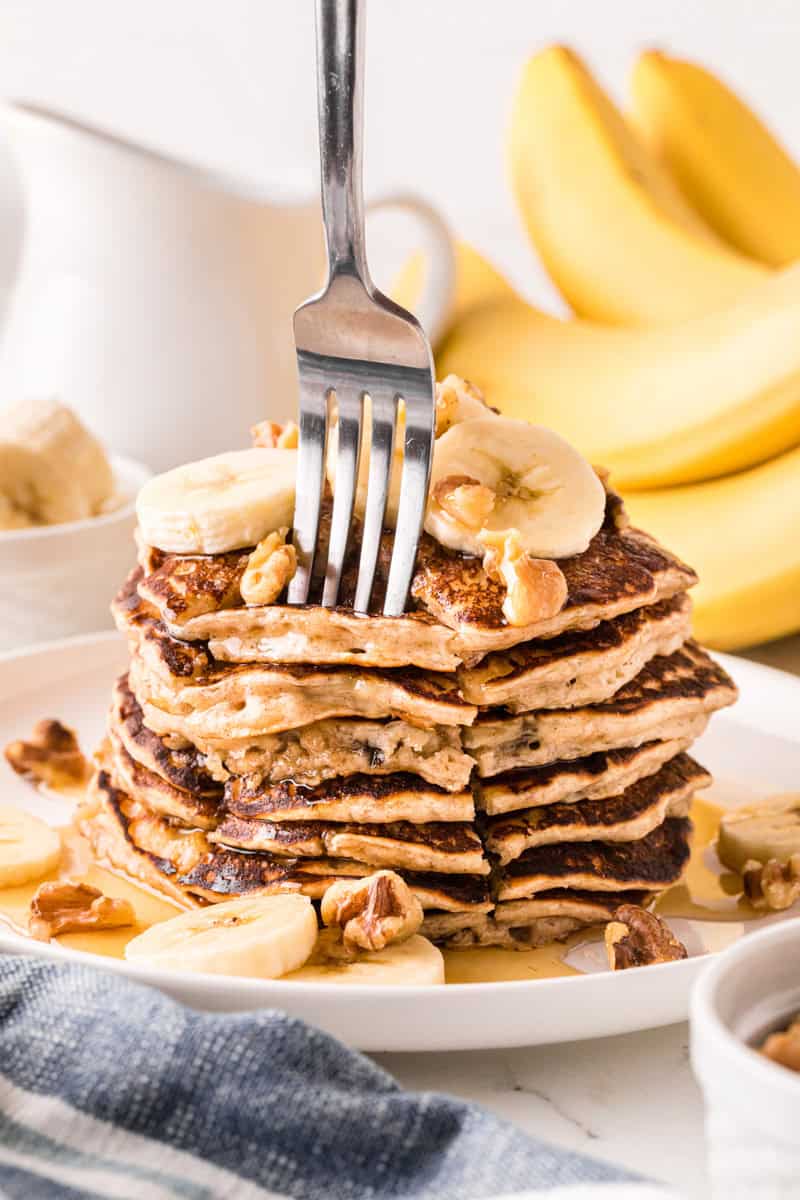 using a fork to grab some of the pancakes.