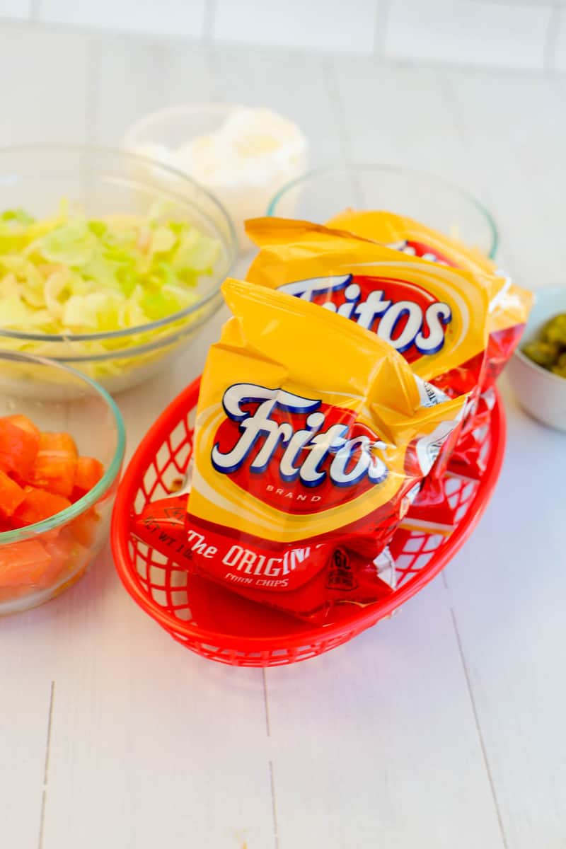 bags of Fritos in a red basket for walking tacos
