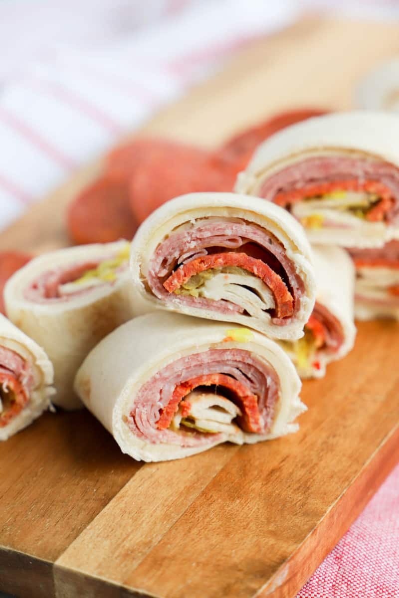 Italian Pinwheels sliced on wooden serving board.