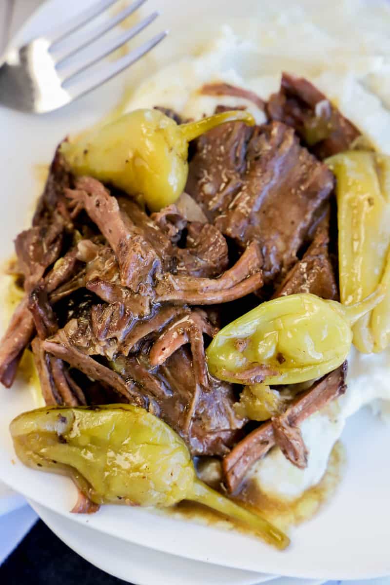 Mississippi Pot Roast on white plate with mashed potatoes on the side