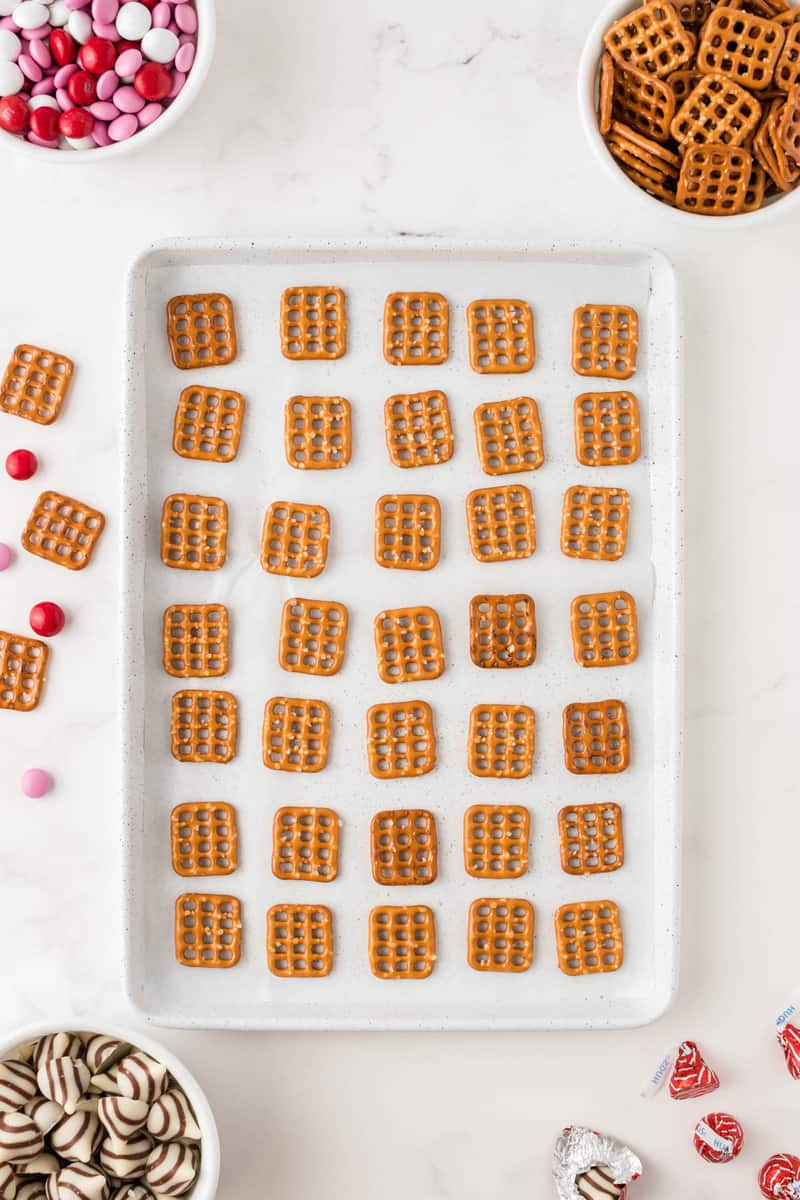 aligning the pretzels on the baking sheet.