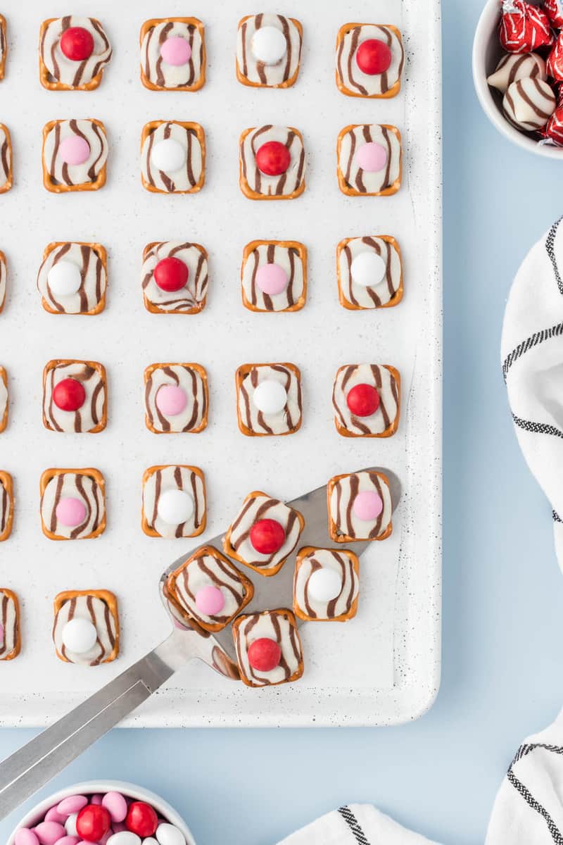 using a spatula to serve the pretzel hugs.