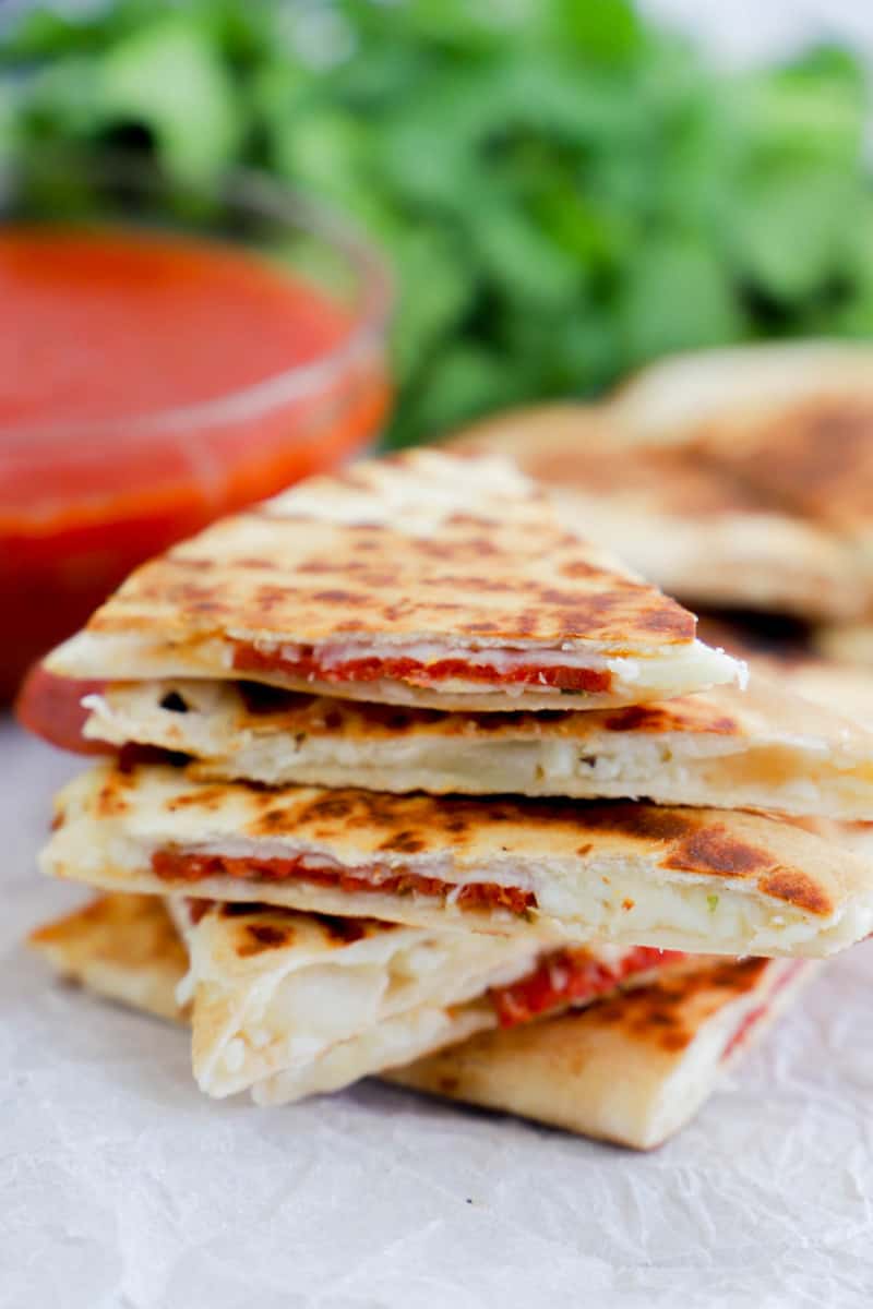 Pizza Quesadillas stacked on parchment paper