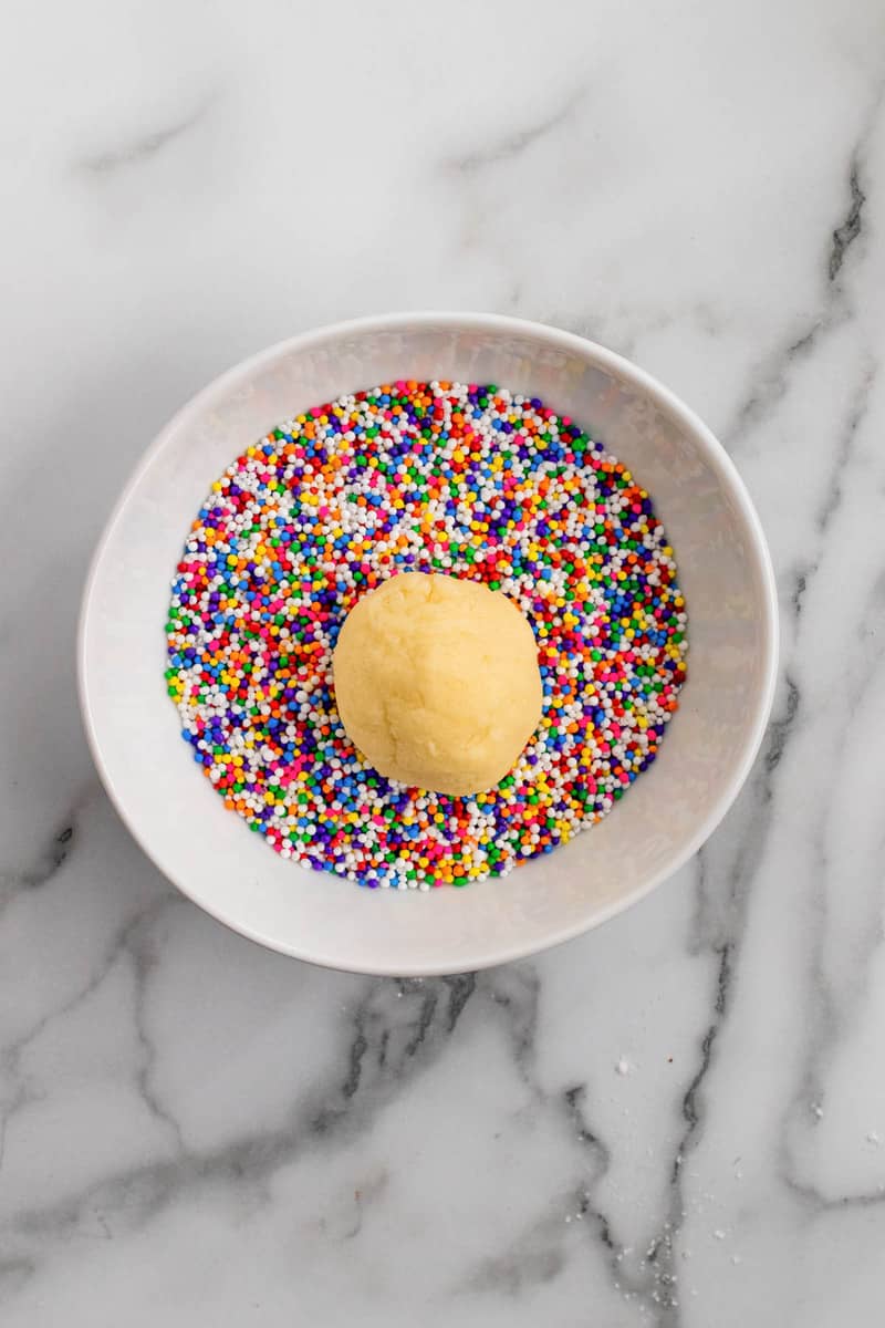 rolling the cookie dough in the sprinkles