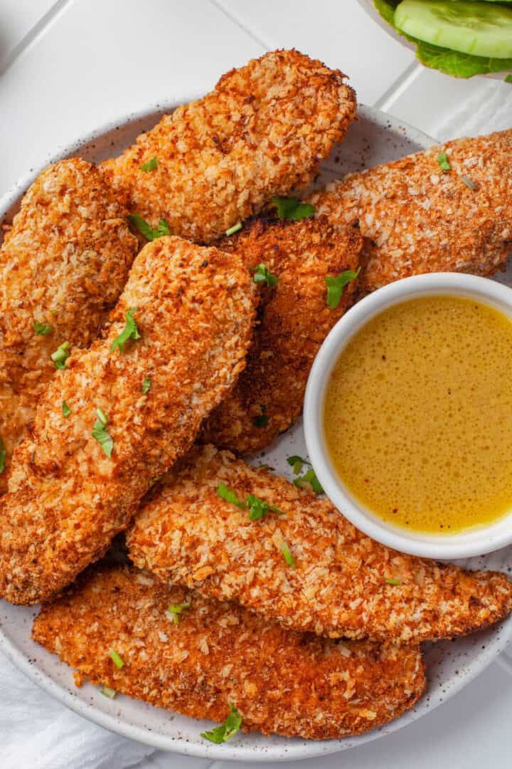 Air Fryer Breaded Chicken Tenders on white plate with dipping sauce