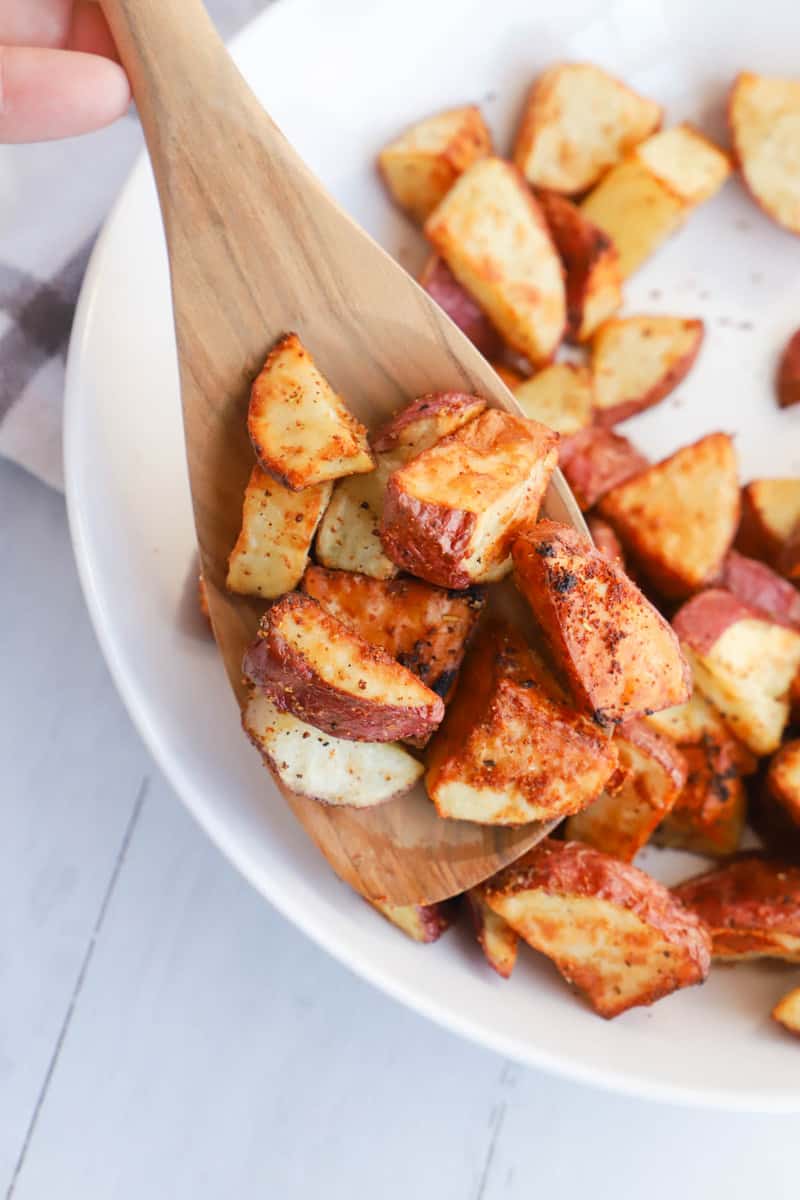 serving the air fryer red potatoes on wooden spoon