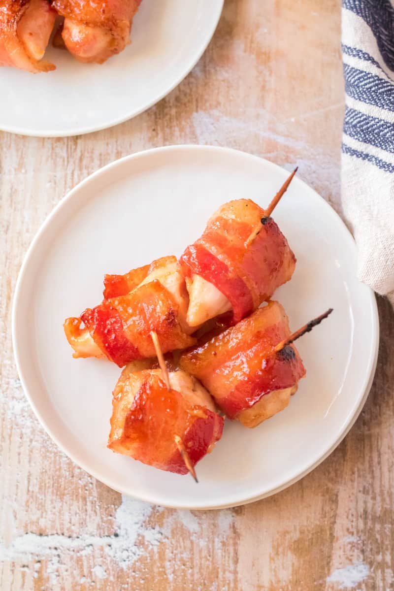 closeup of bacon wrapped chicken bites on white plate
