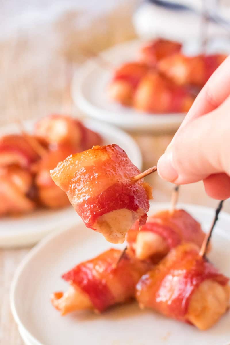 bacon wrapped chicken bite in hand close up