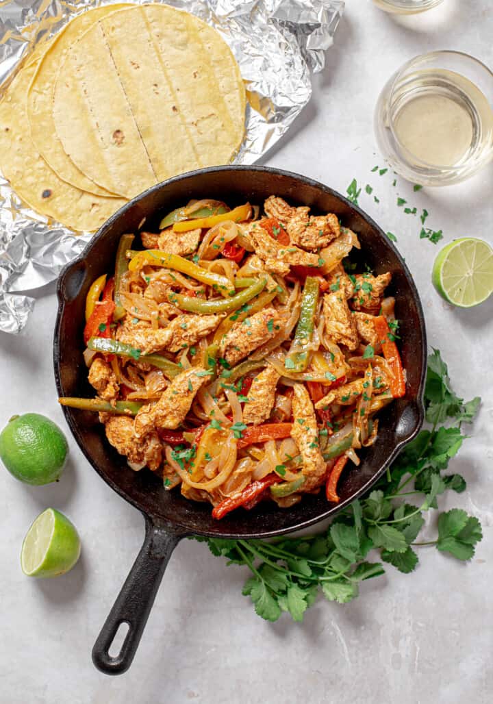 Peppers onions and chicken cooked in the skillet.