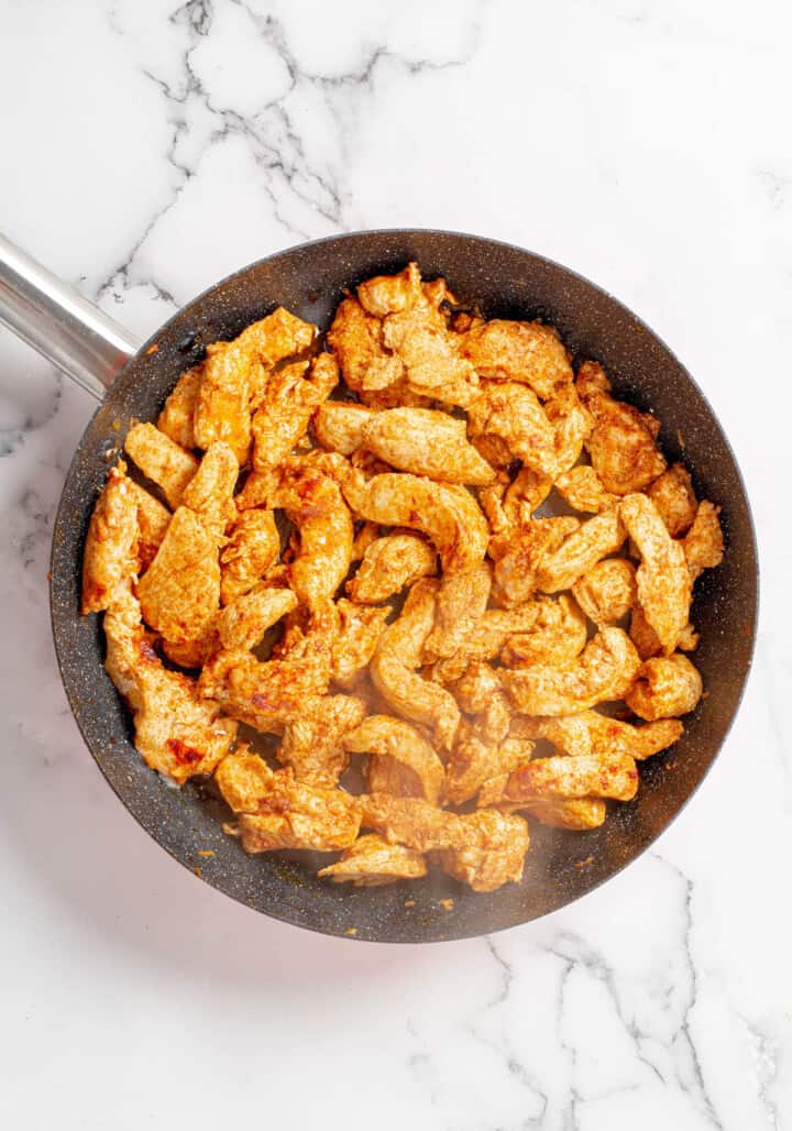 Cooking chicken in a skillet for the fajitas.