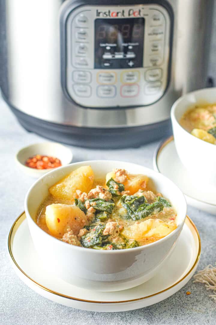 zuppa toscana in white bowl in front of instant pot