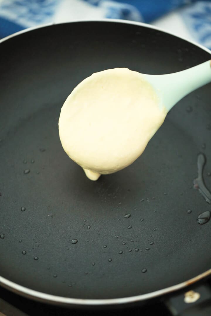 scooping pancake mix on to skillet