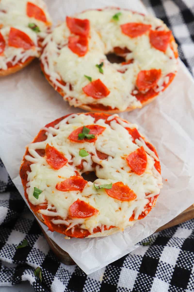 Pizza Bagels on parchment paper on wooden serving board