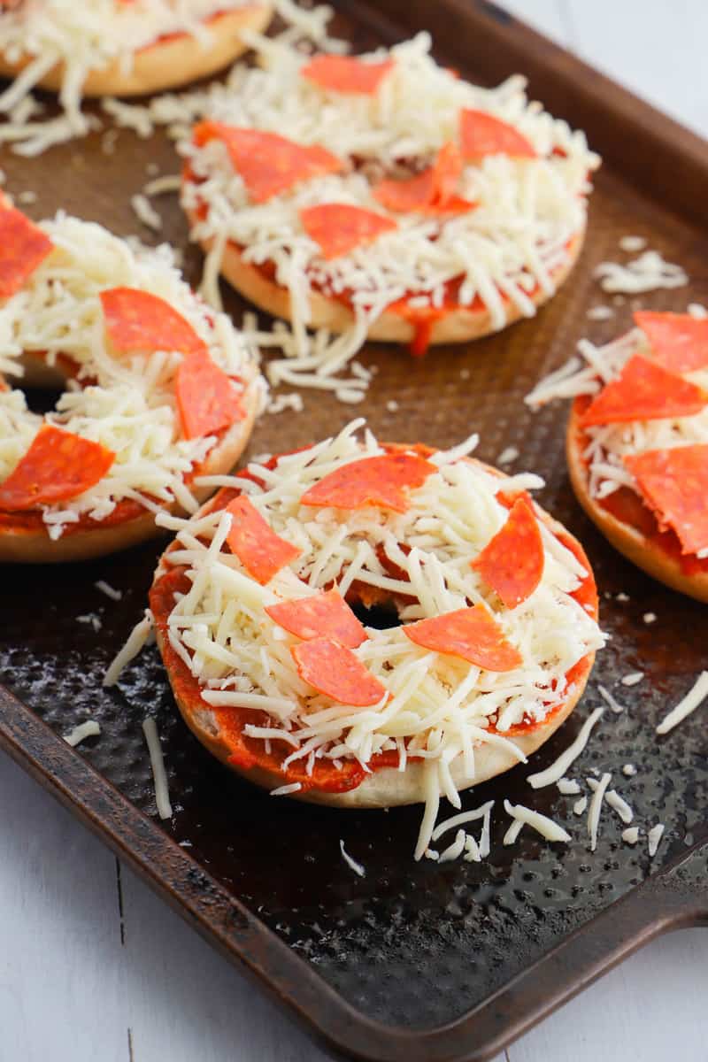 pizza bagels on baking sheet before going in the oven