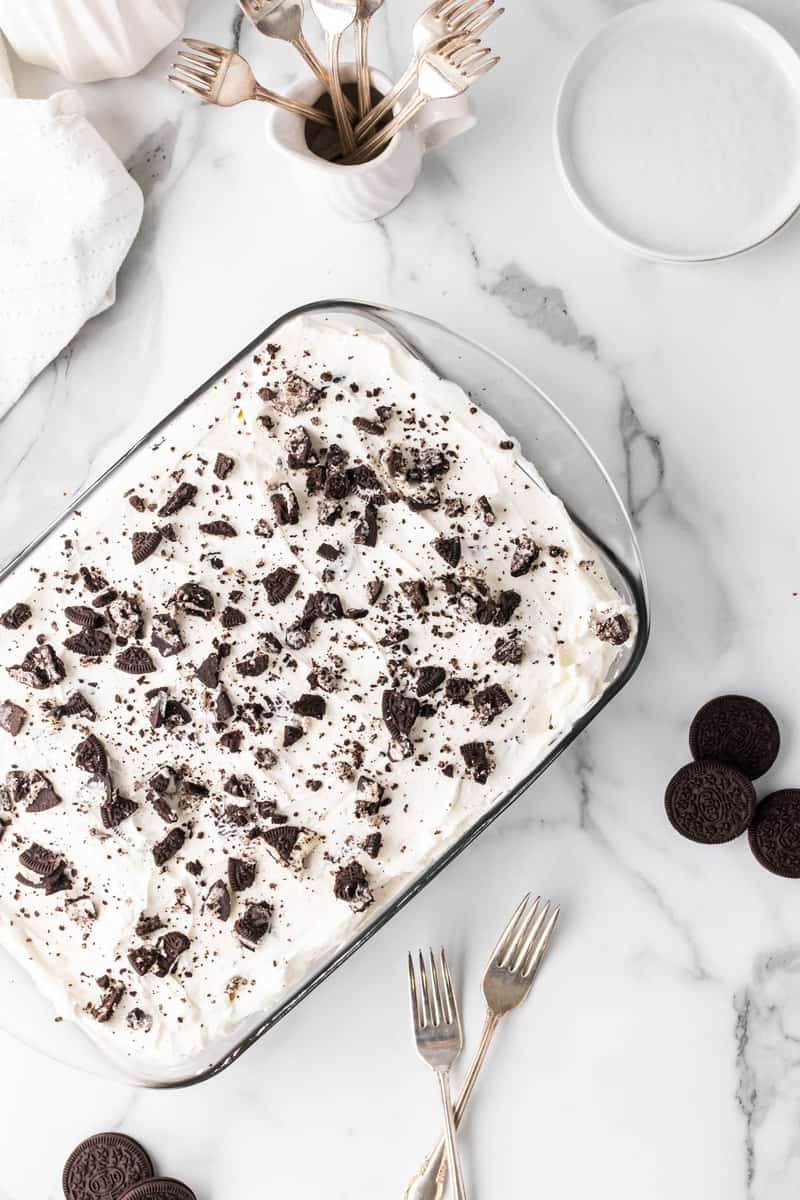 Oreo poke cake in baking dish on marble counter