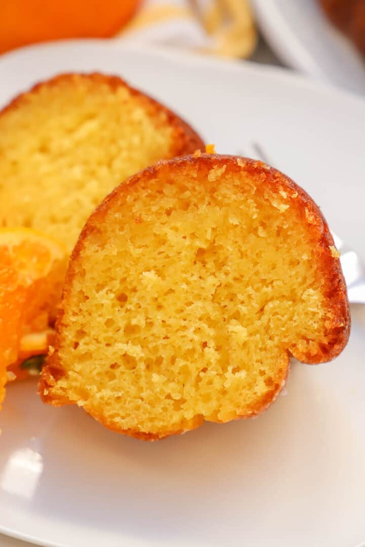 close up of orange juice cake on white plate