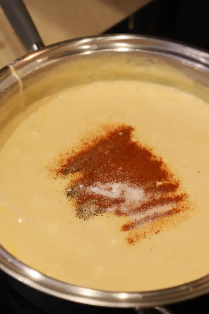 adding the seasoning to the cheese sauce
