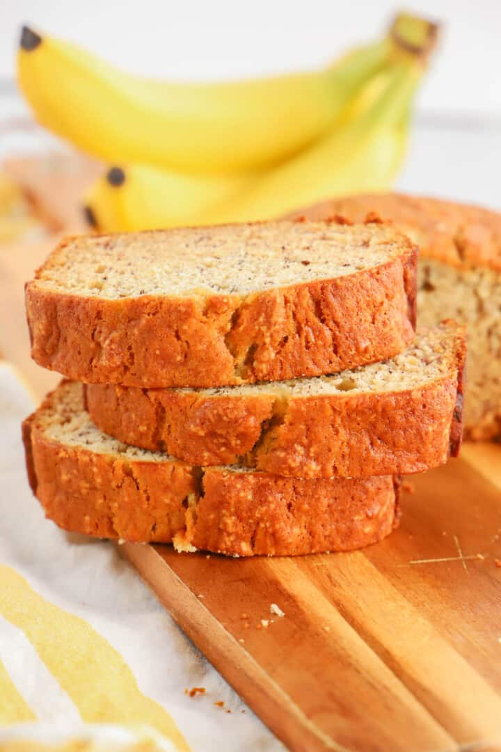 slices of banana bread stacked on wooden serving board