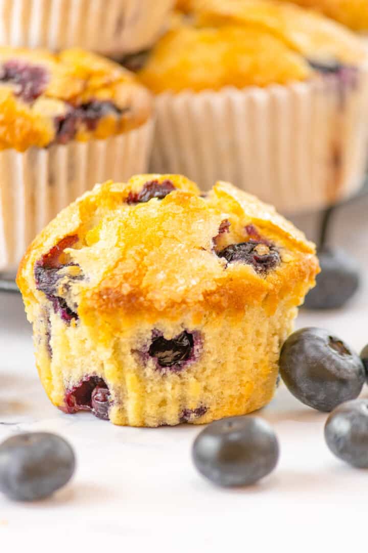 Blueberry Muffins close up with fresh blueberries next to it.