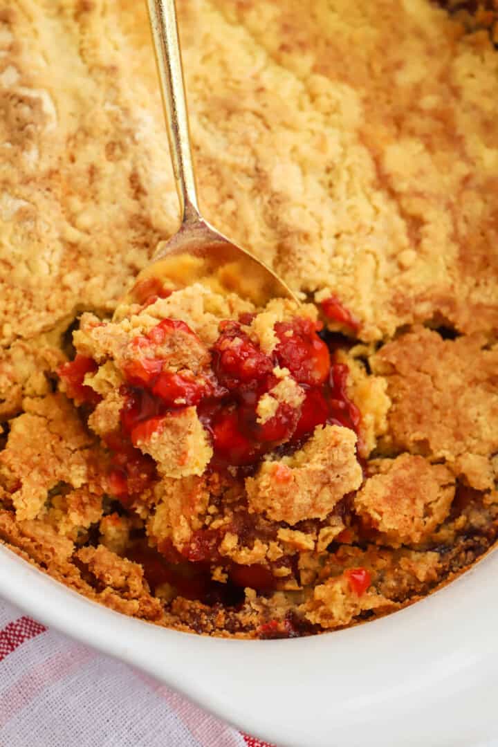 scooping the Cherry Dump Cake out with a metal spoon