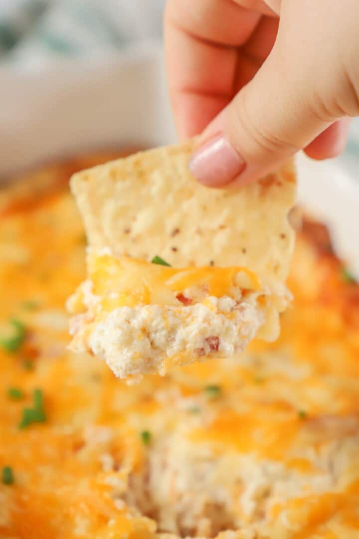 close up of crack chicken dip on a tortilla chip