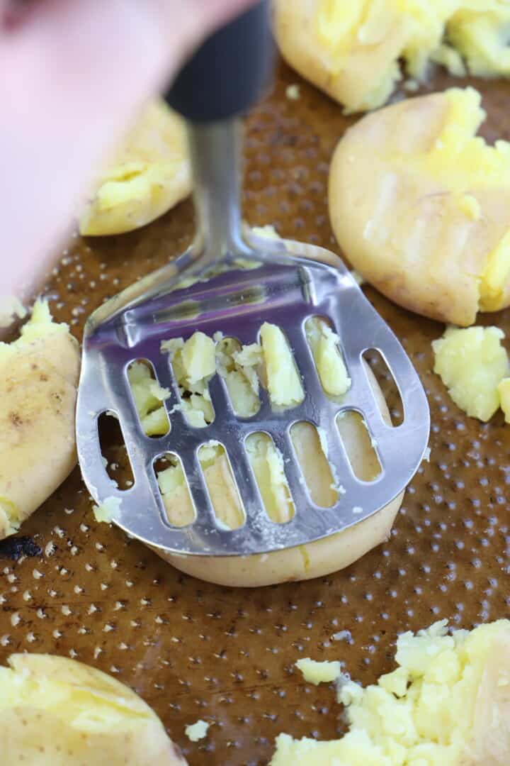 smashing the potatoes with potato masher