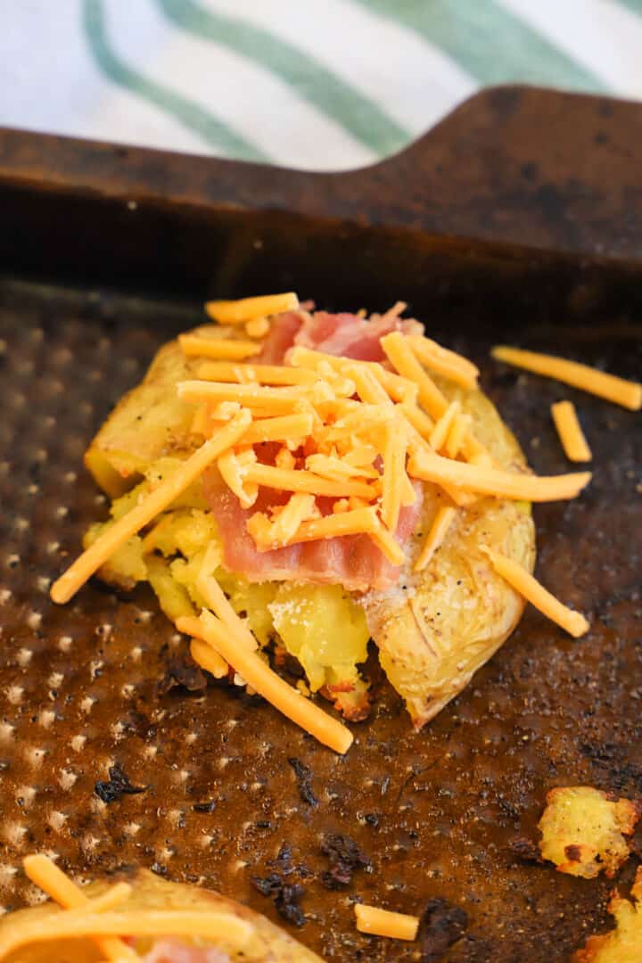 topping the potatoes with the cheese and bacon