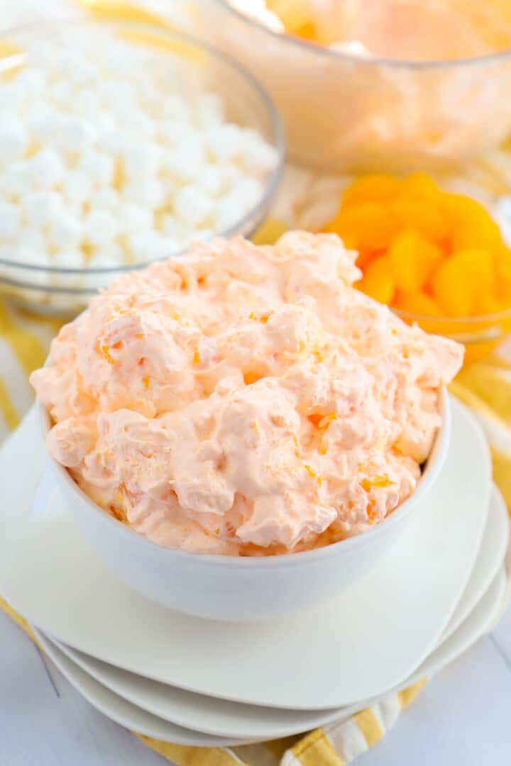 orange fluff in white bowl stacked on white plates