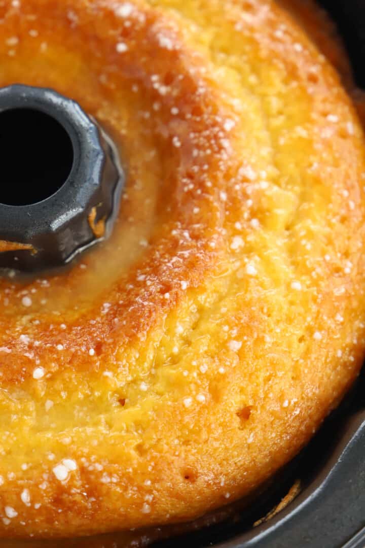 pouring orange juice glaze over cake